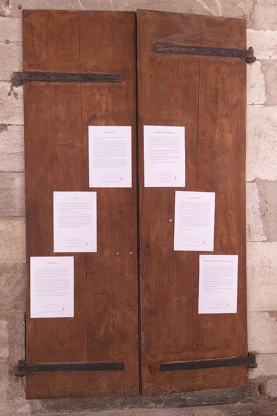 La double porte en chêne avec les textes placardés dessus