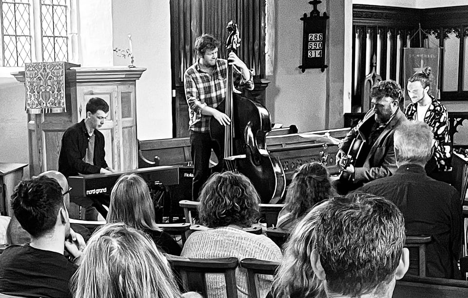 A jazz quartet with keyboard, bass guitar and drummer