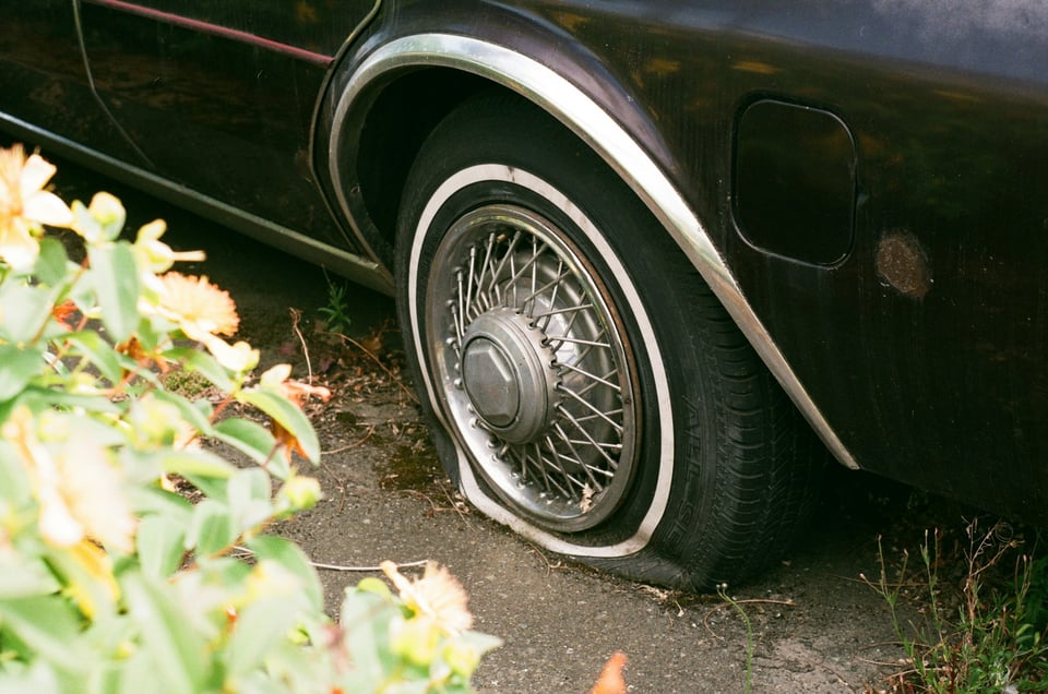 A close-up shot of a flat tire. Photo by Sebastian Huxley on Unsplash