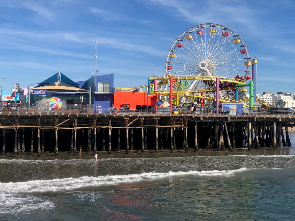 Photo of the Santa Monica Pier with Ferris wheel visible and Pacific Ocean in the foreground (Photo: Liz Ohanesian)