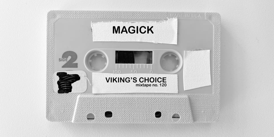 a cassette without a case. tape affixed to various sections that name the tape "magick"