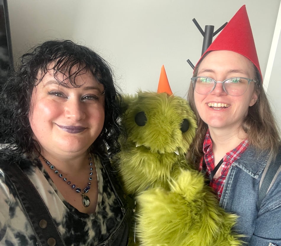 two ladies and a green goblin puppet