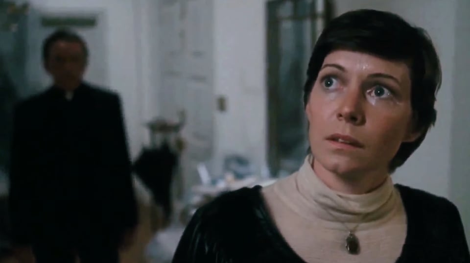 Wide-eyed Kitty Winn as Sharon looks fearfully up the stairs towards the bedroom where the original possession happened, in Exorcist II: The Heretic