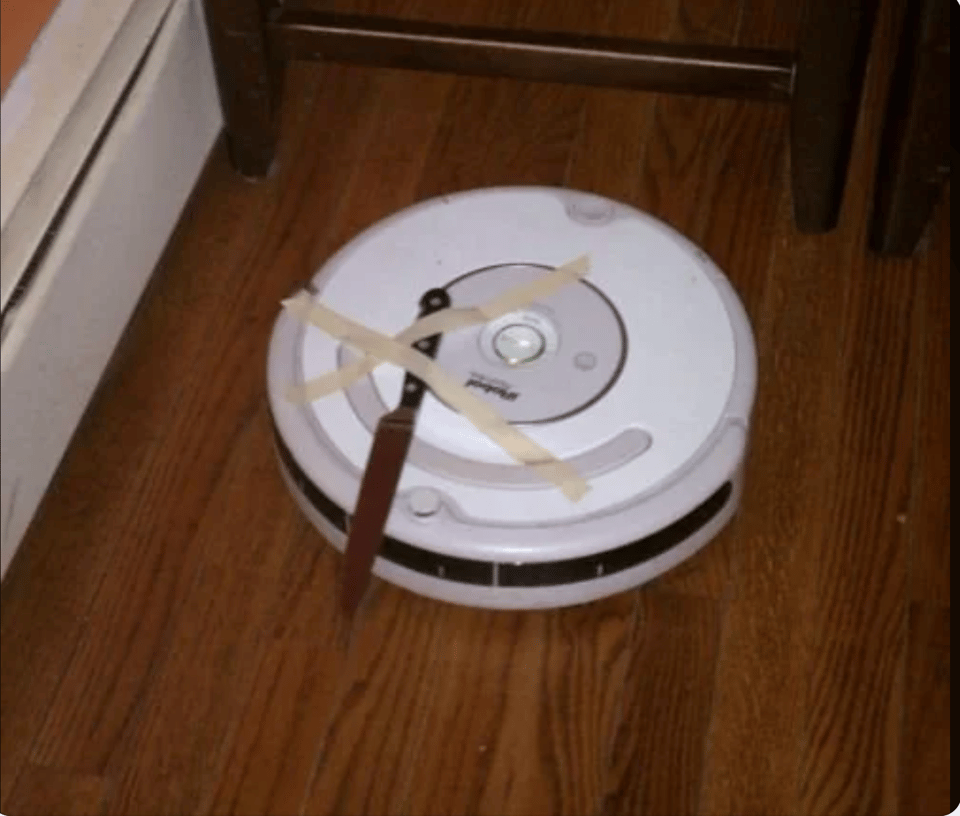 A white Roomba with a knife taped to it