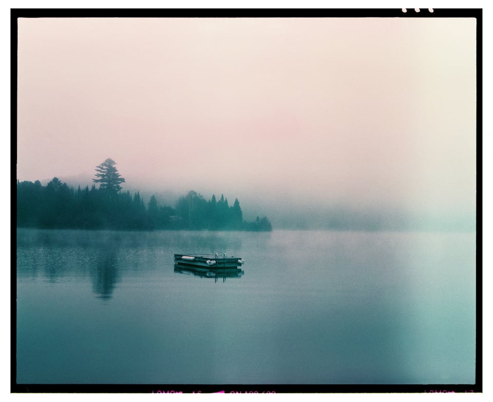 A misty lake with a floating dock