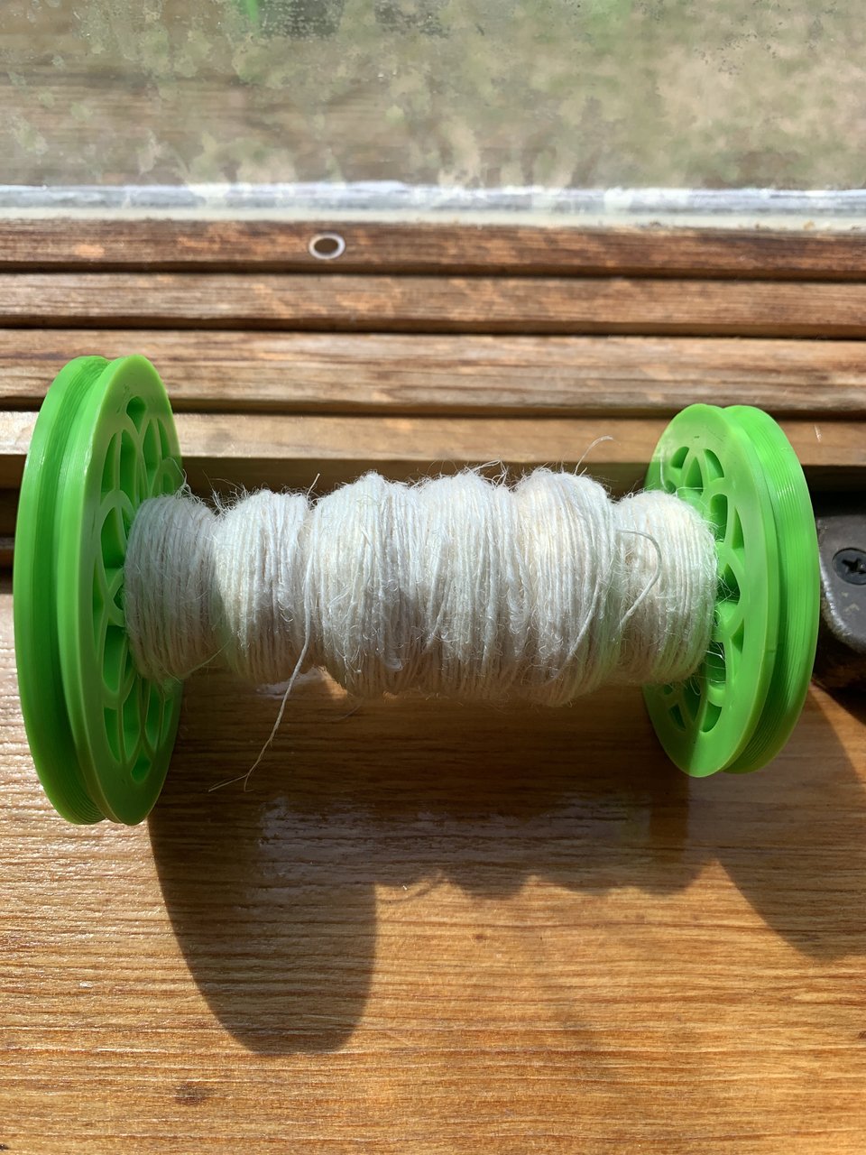 neon green bobbin full of handspun linen thread. 