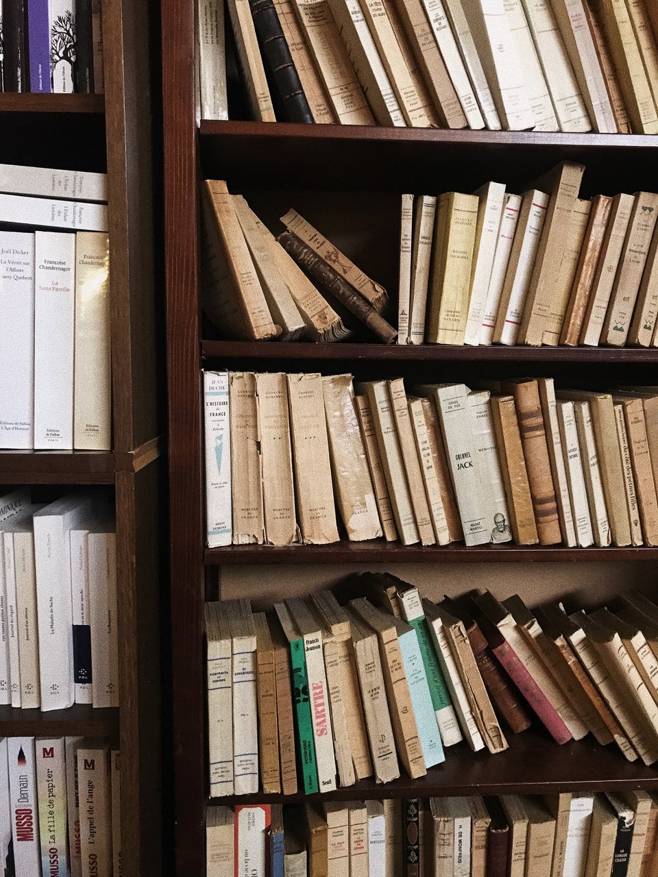 Image of a shelf full of old, worn books.