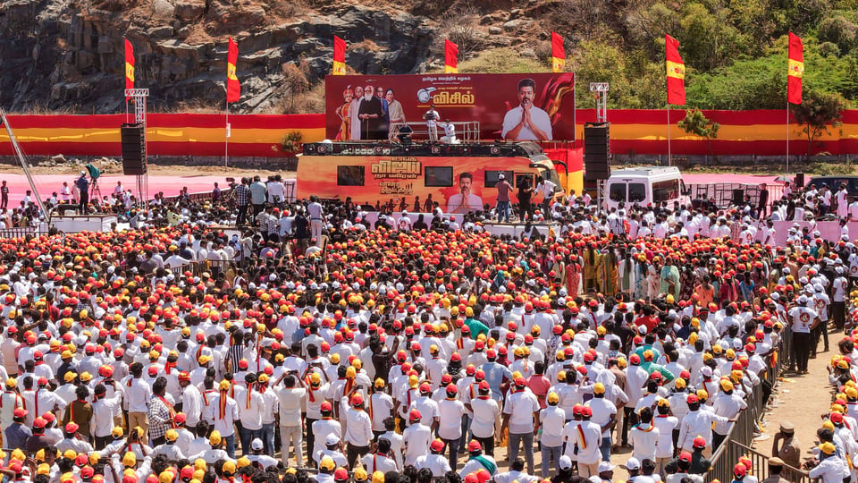 A sea of people wearing red and yellow caps take part in a political rally