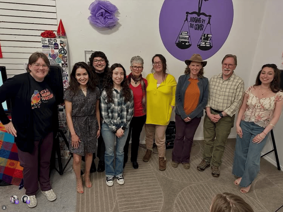 Writers and artists gather for a group photo, inside a local bookstore.
