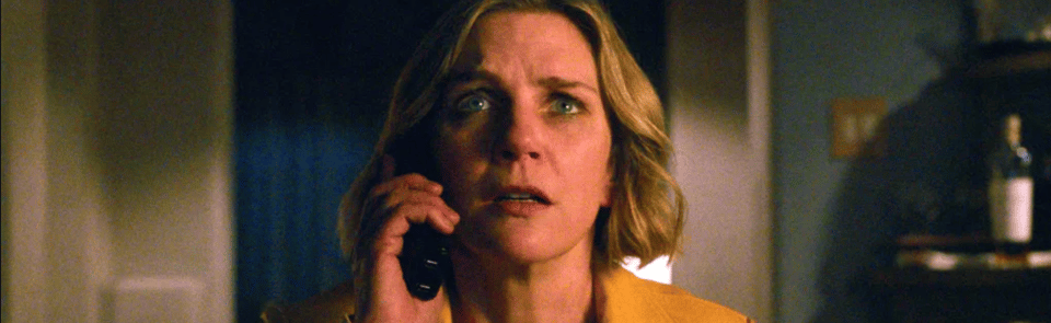 A screenshot from Pluribus. Rhea Seehorn as Carol is on the phone, staring dead ahead in dread.