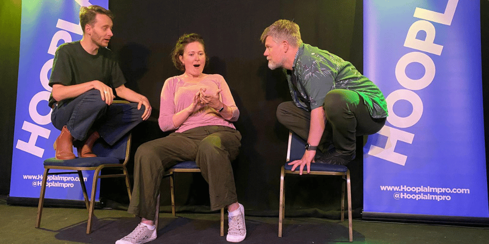 Three improvisers sitting on chairs in different ways.