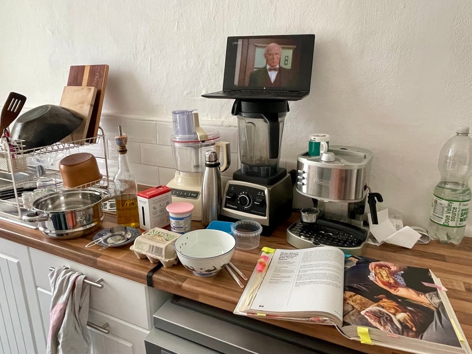 Ingredients, a cookbook and a laptop laid out