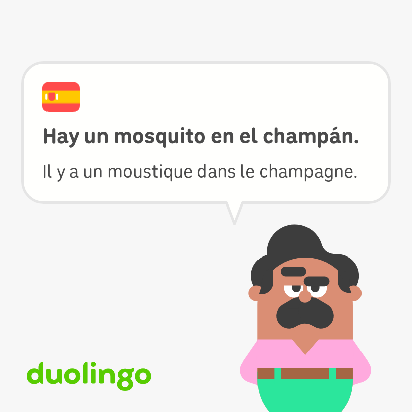 Oscar, a mustachioed art teaching who wears a pink shirt and green pants says, “There is a mosquito in the champagne,” in French and Spanish