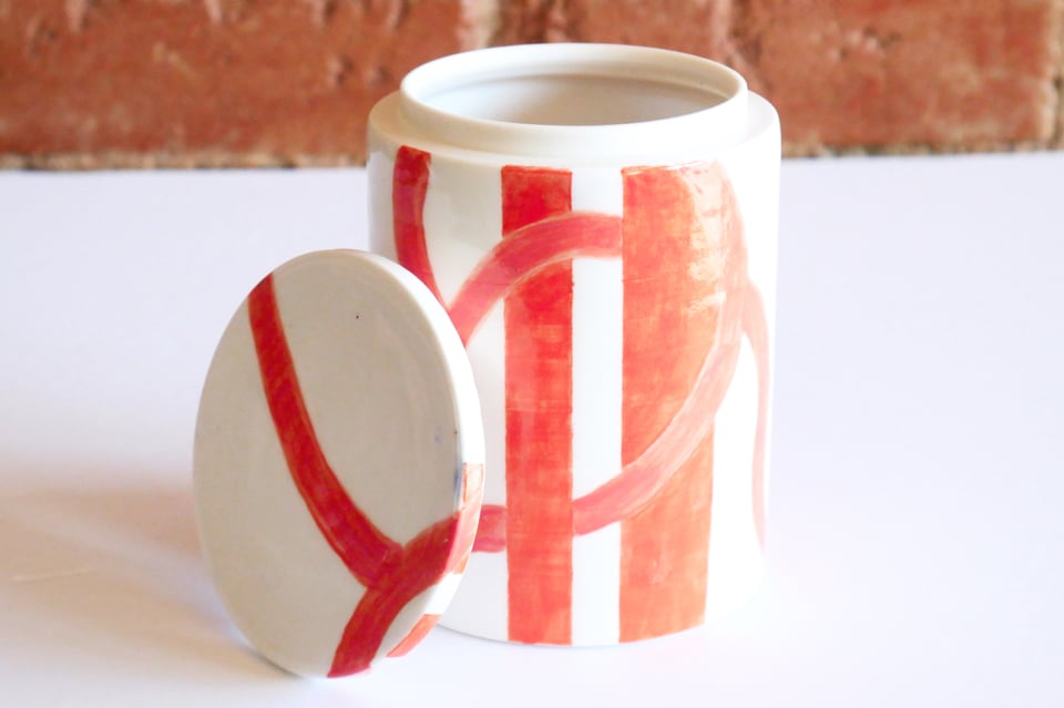porcelain white jar with orange stripes and swirls that match our wall