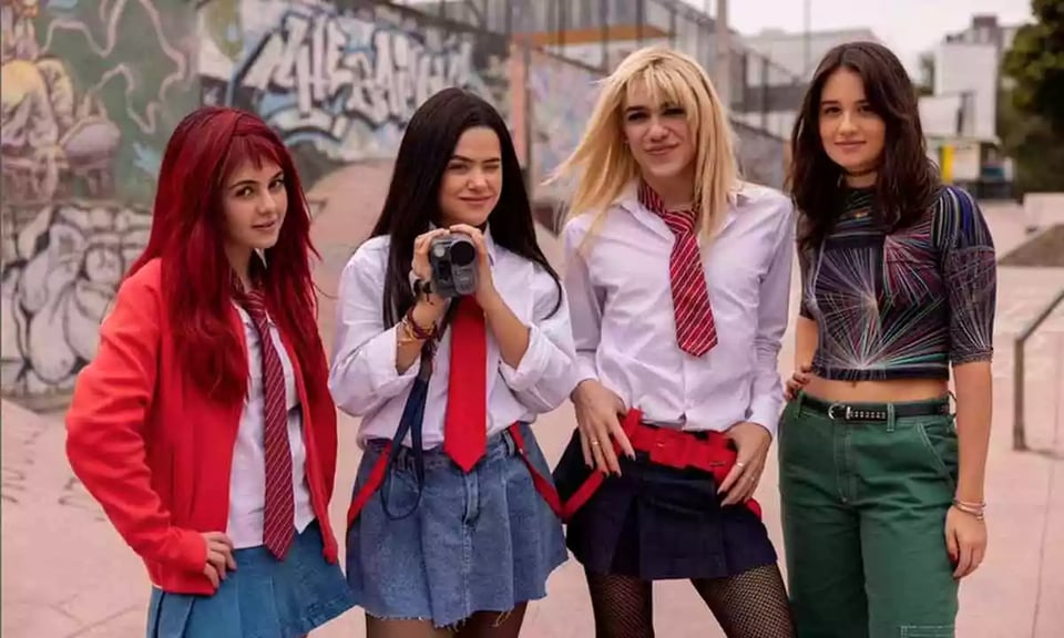 Carol, Anita and Camila (three teen characters) dress up in schoolgirl outfits and wigs, while Anita's sister Luiza is wearing a shirt with fractal patterns and green pants, in season two of Back to 15