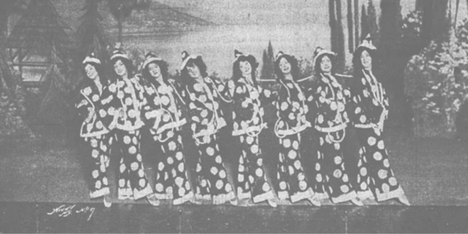 Black and white newspaper photo showing 8 women wearing pirotte costumes.