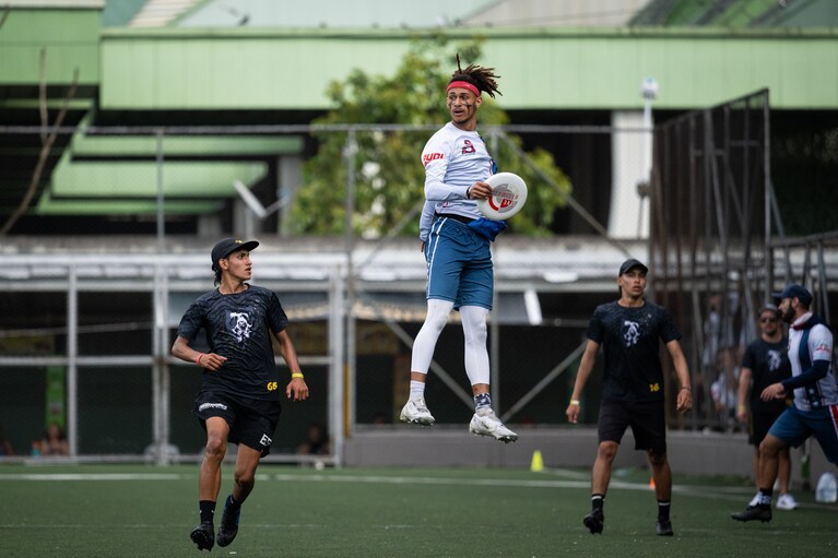 a frisbee player jumping high in the air