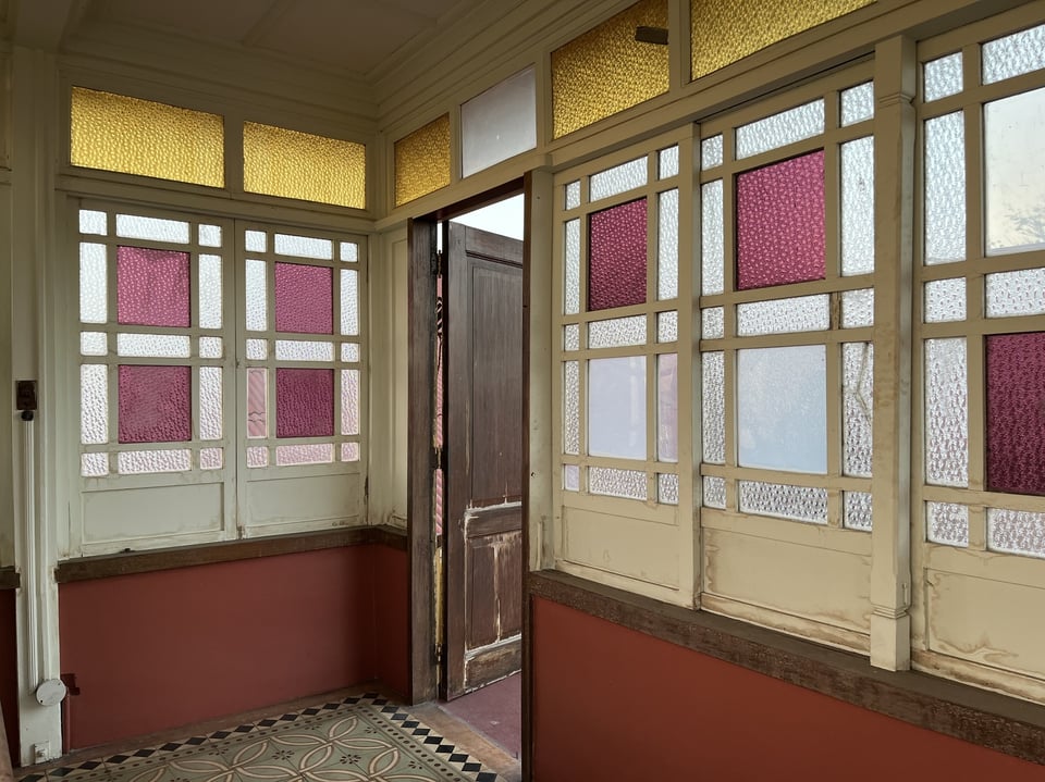 old window panes, including some very pretty pink ones, and an open door