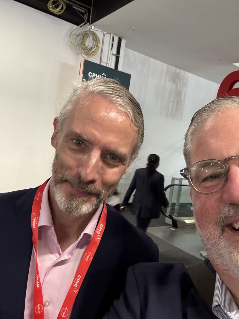 selfie of two white men, one of whom has positioned himself so barely half his face is in frame. They're both in suit jackets.
