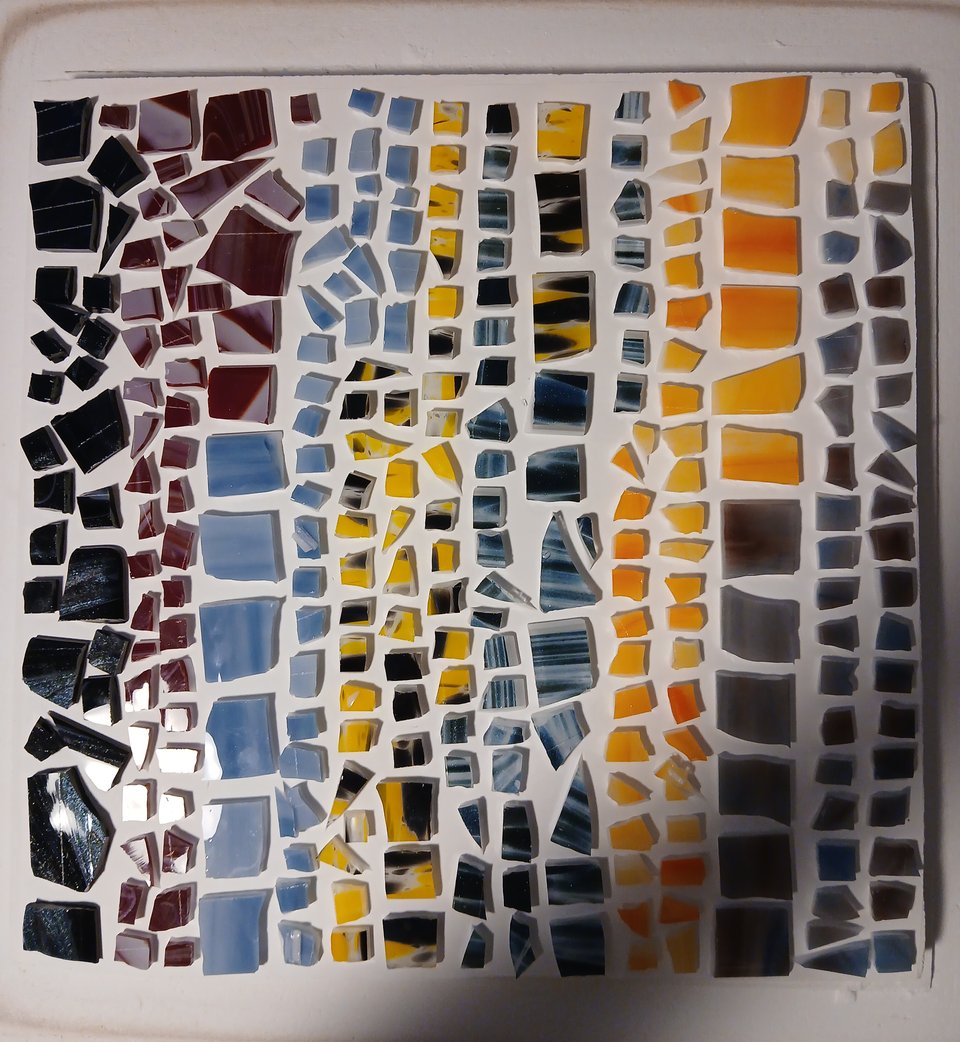 kiln shelf with chopped up glass in a sparkly galaxy pattern, white/red, cloudy blue, yellow/black, rippling blue, orange/yellow and blue/mauve