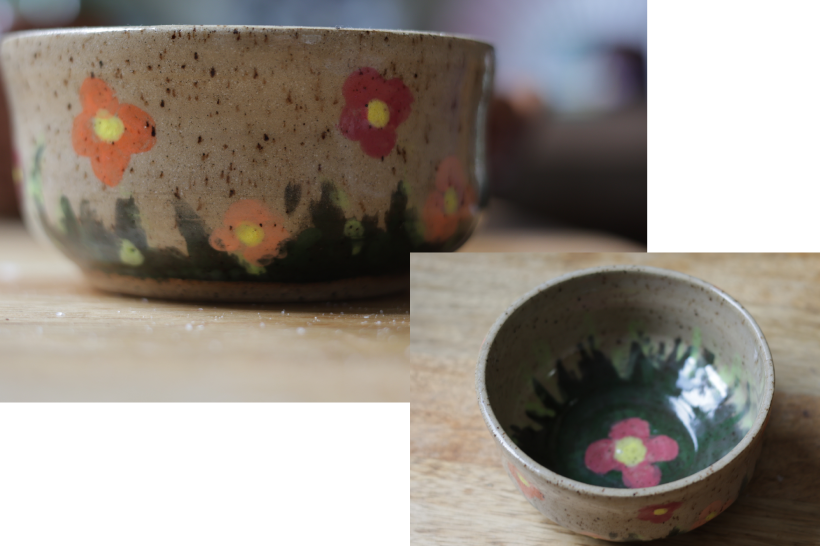 A collage of two images of a handmade ceramic bowl. The larger image shows the bowl from a side view, where you can see painted grass along the bottom and simple orange, pink, and purple flowers above that, all on a speckle brown clay background. The smaller image shows the inside of the bowl from a top-down perspective, which has a pink flower centered inside an more green grass around it.