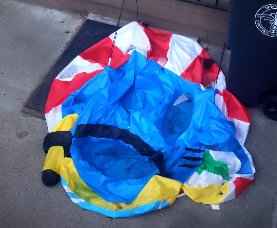 A flat, deflated inflatable decoration. The main body is blue. Inflated, it would be a shak with an inner tube, snorkel mask, and beach ball.