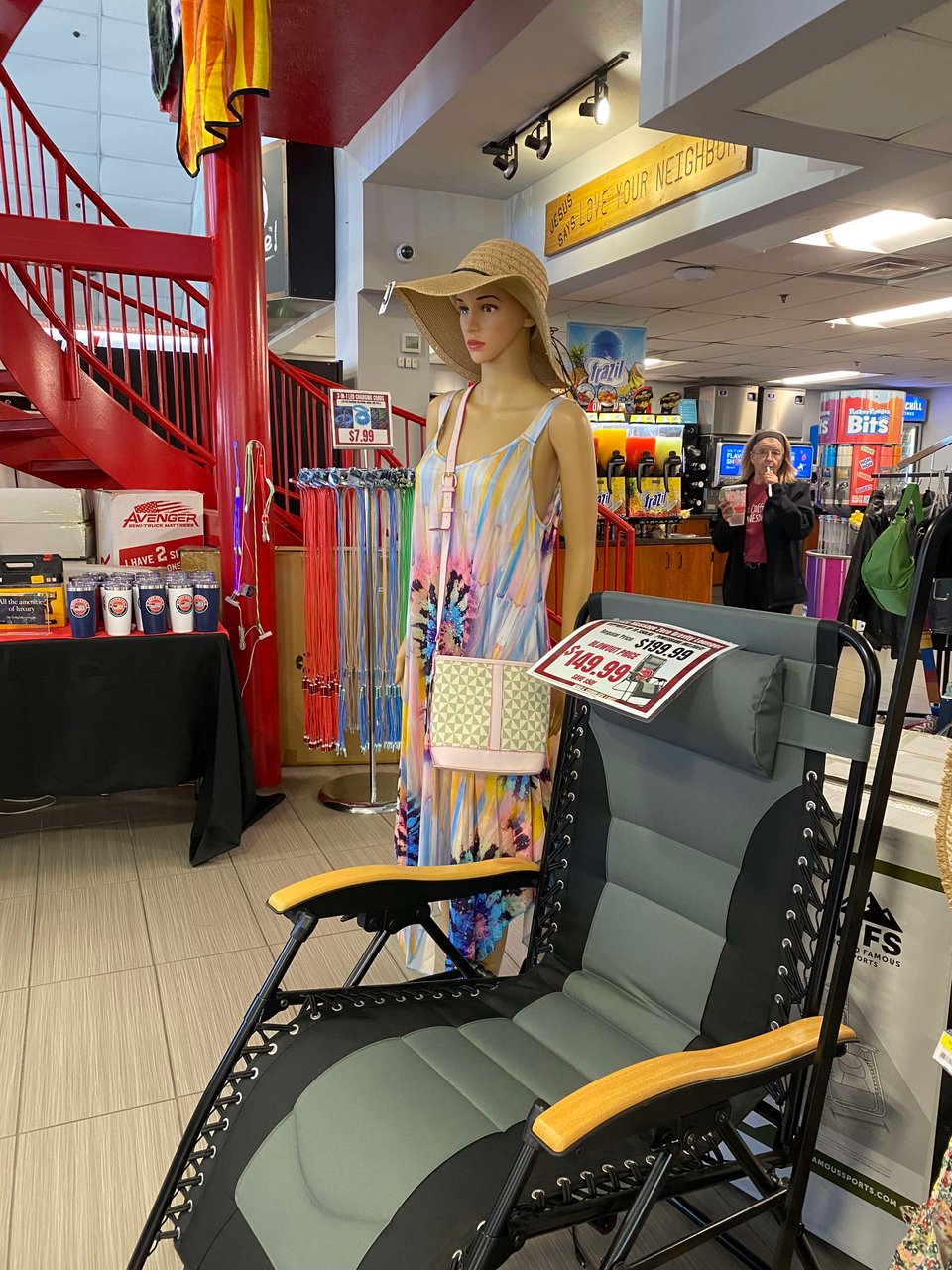 a very expensive outdoor lounge chair for $149.99 and a tall woman mannequin in the inside of a truck stop