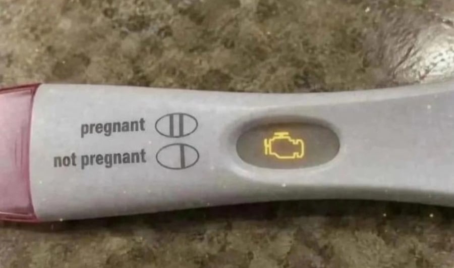 A photo of a pregnancy test, but instead of the lines, it's showing a Check Engine light from a car's dashboard.
