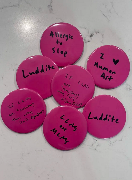 Pile of 7 hot pink button pins with slogans like, "Luddite", "I love human art", "Allergic to slop", "LLMs are MLMs", and "If LLMs are 'conscious', then why isn't AlphaFold?"