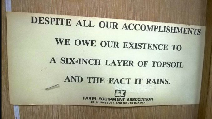 sign from the farm equipment association of minnesota and south dakota: despite all our accomplishments we owe our existent to a six-inch layer of topsoil and the fact it rains