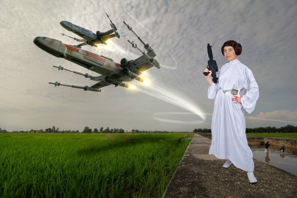 A crudely photoshopped image of a woman dressed as Princess Leia against a picture of a field that has two X-Wing fighters flying over it.