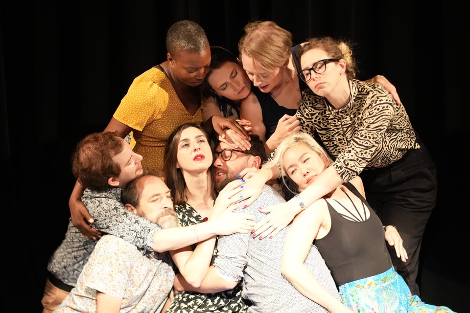 A group of people hugging on stage.
