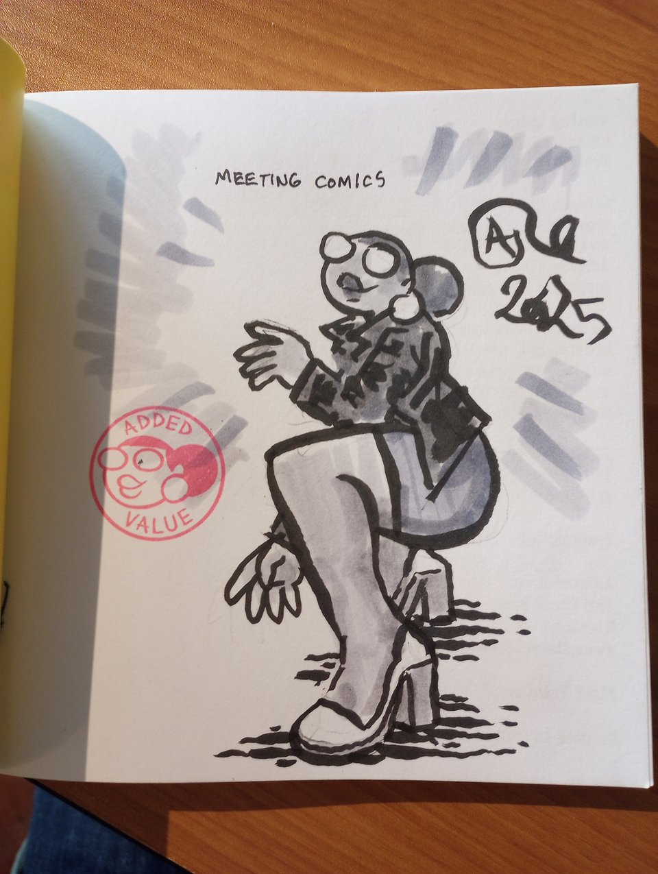 A drawing of Val inside a copy of Meeting Comics.