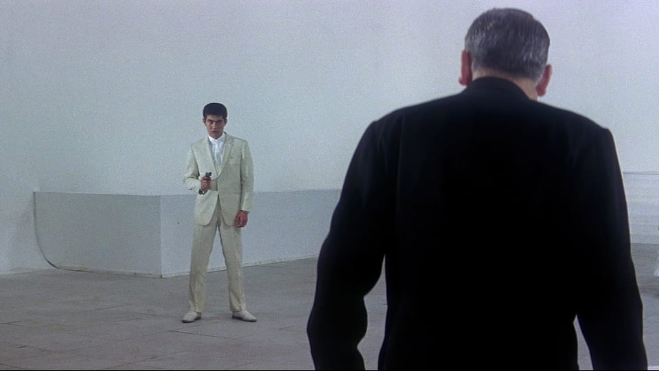 A shot from Tokyo Drifter where the protagonist in white points his gun at <spoiler>