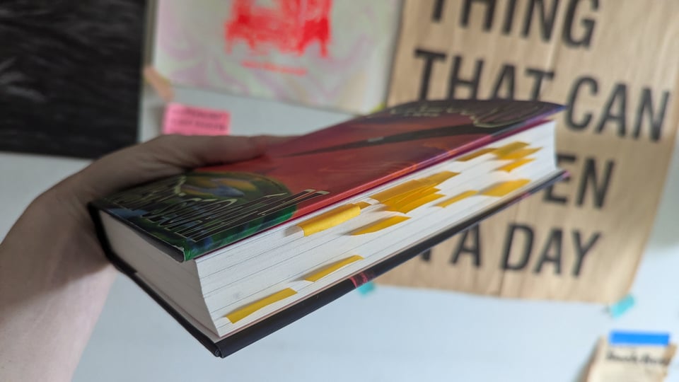 A photo of the book Moonbound with many little yellow post it notes sticking out of it.