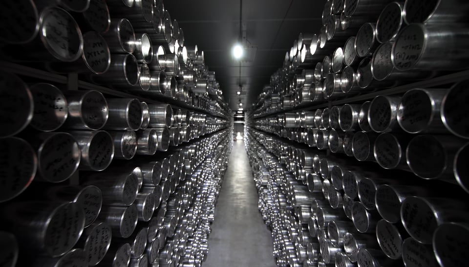 Long corridor with stacks of metallic tubes on each side.