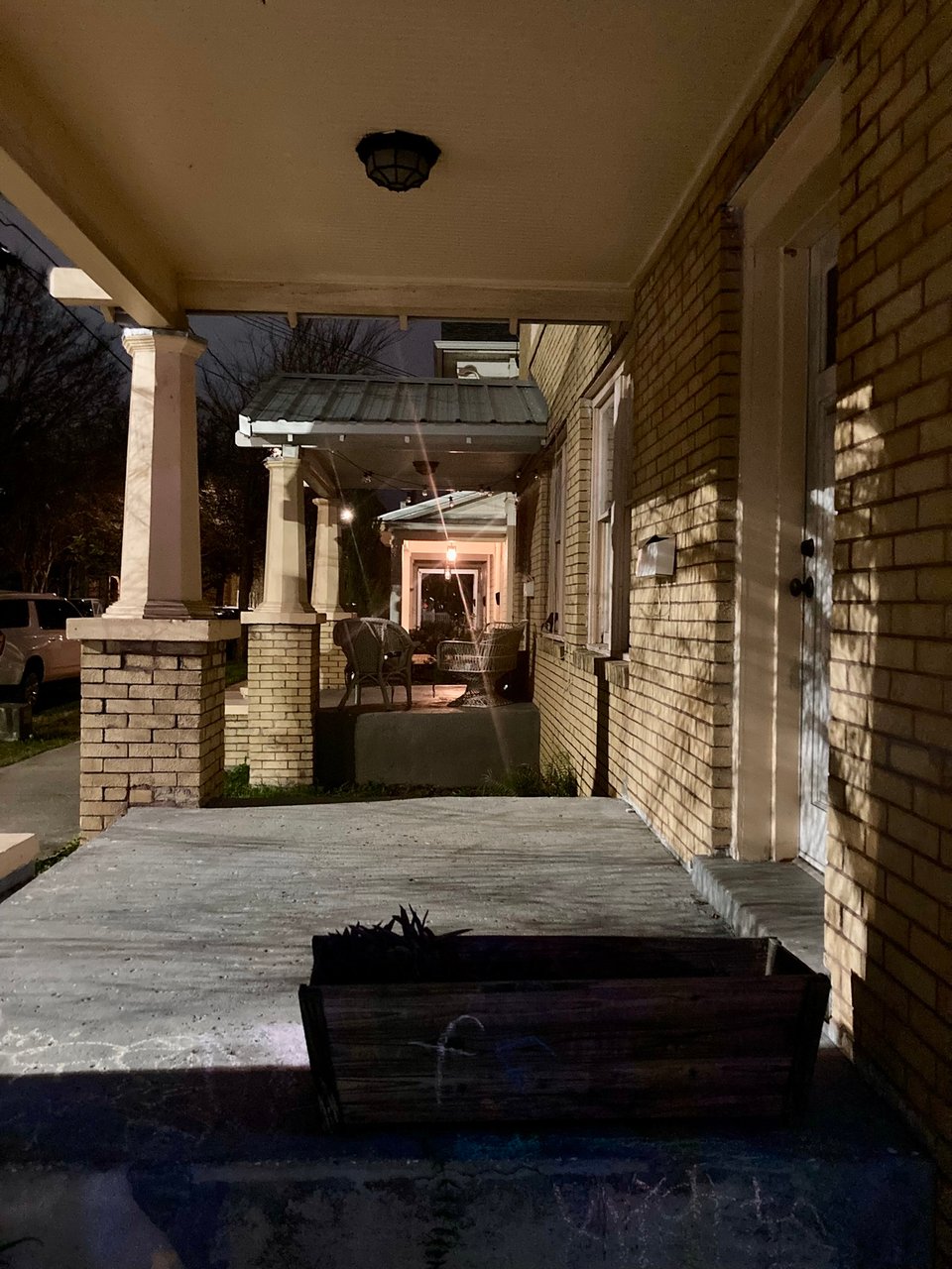 A nighttime photo of a series of porches in a line.