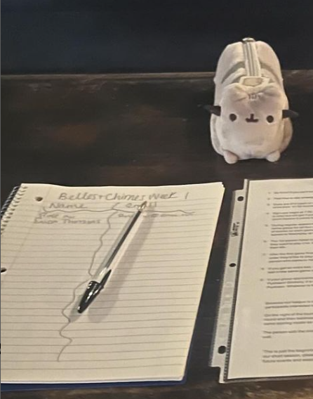 An image of a table with a sign up sheet and adorable stuffed Pusheen.