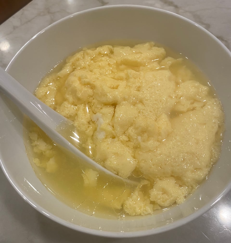 white soup spoon in white bowl of chawan mushi, Japanese egg custard