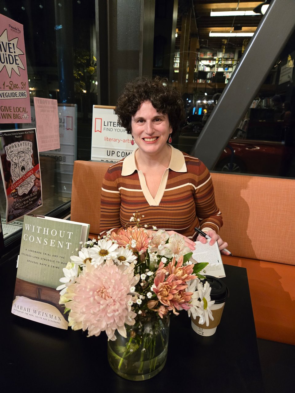 Signing books at Literary Arts Bookstore in Portland, OR with a flower arrangement that matches my dress (photo: Sara Ryan)