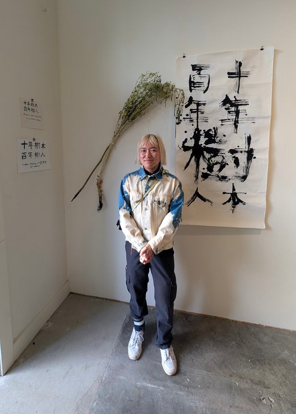 Lio Min stands next to the work they presented at "Respond to Tree," curated by Robin Milliken at the Oakland gallery Confloptus.