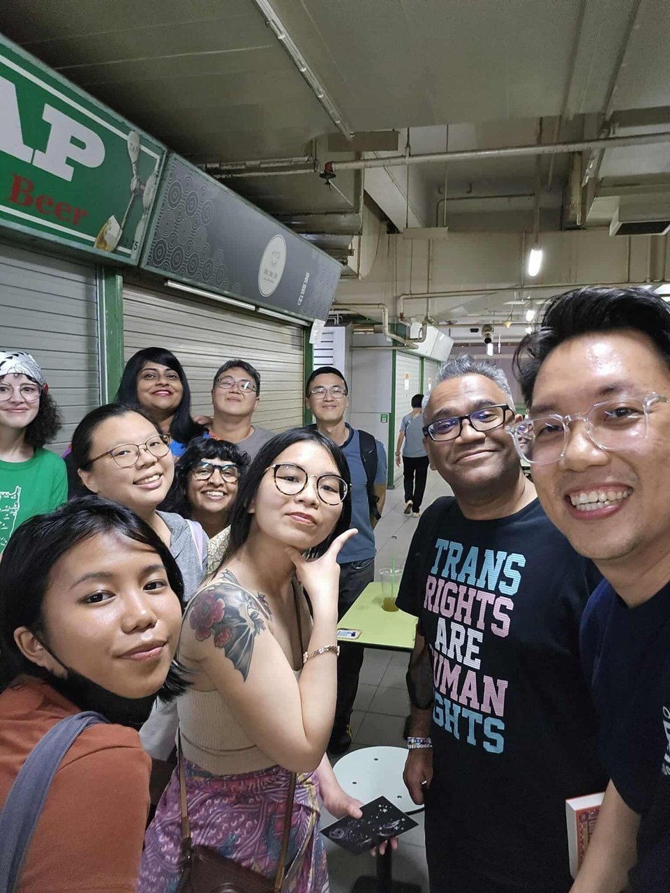 A selfie of a group of people in a hawker centre at night.