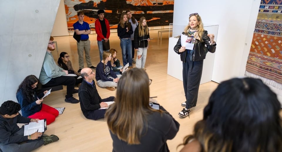 JMC Prof. Amanda Flaim, inside the Broad Art Museum and presenting in front of a group of students.