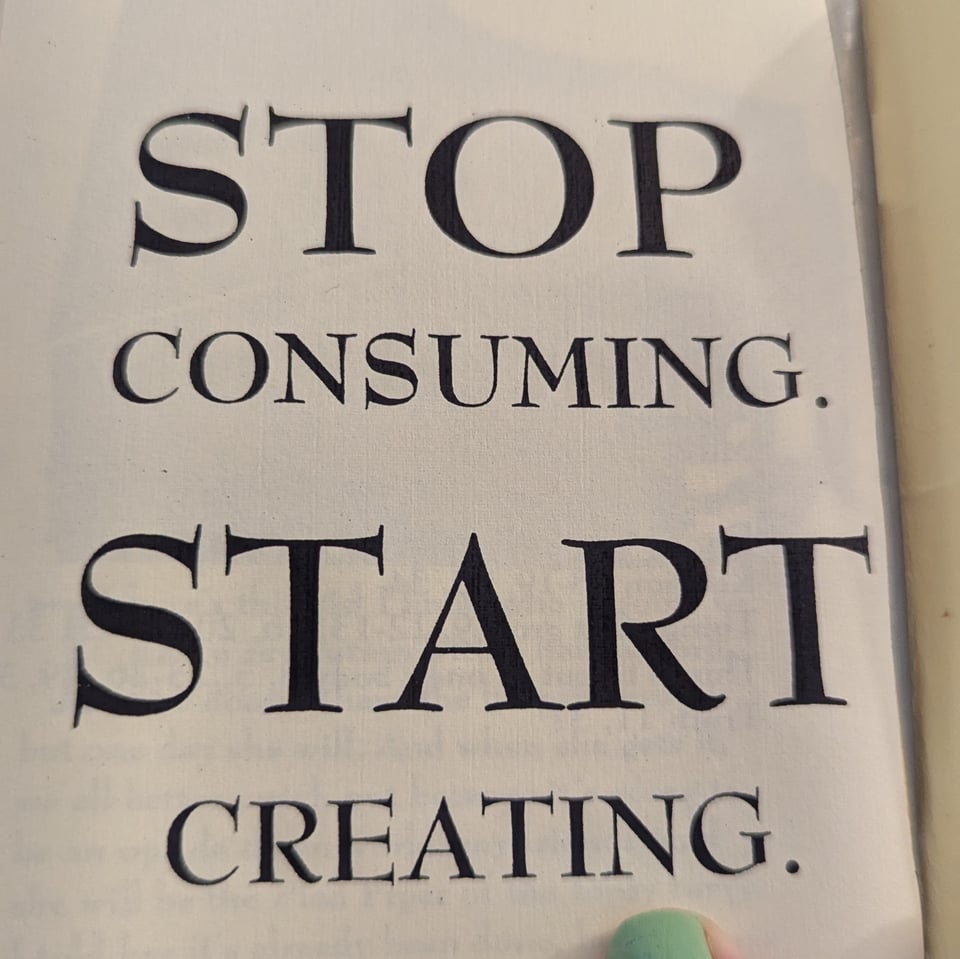A photo of the first page of a zine. It reads Stop Consuming. Start Creating.