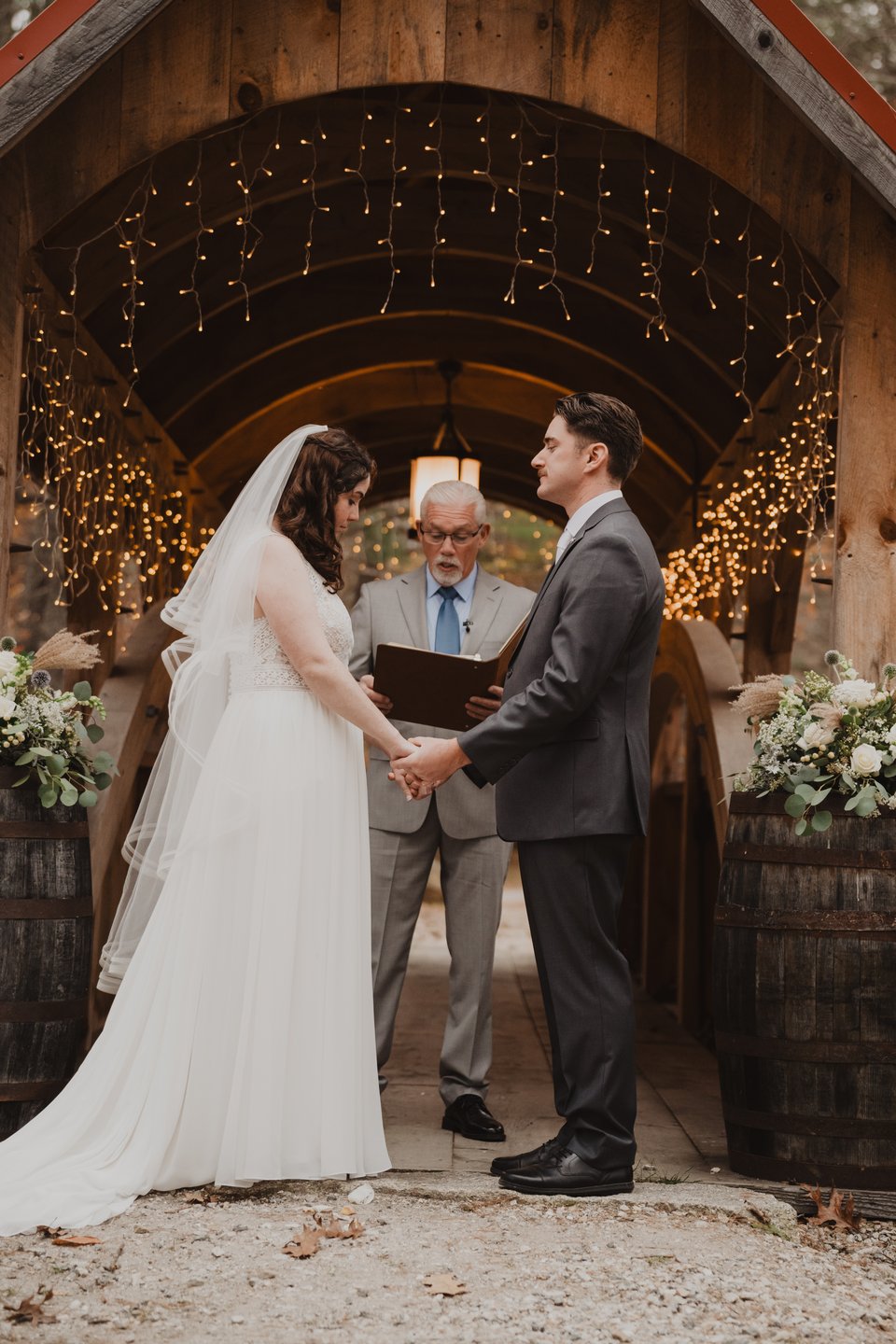 a bride and groom exchanging vows in a barn
