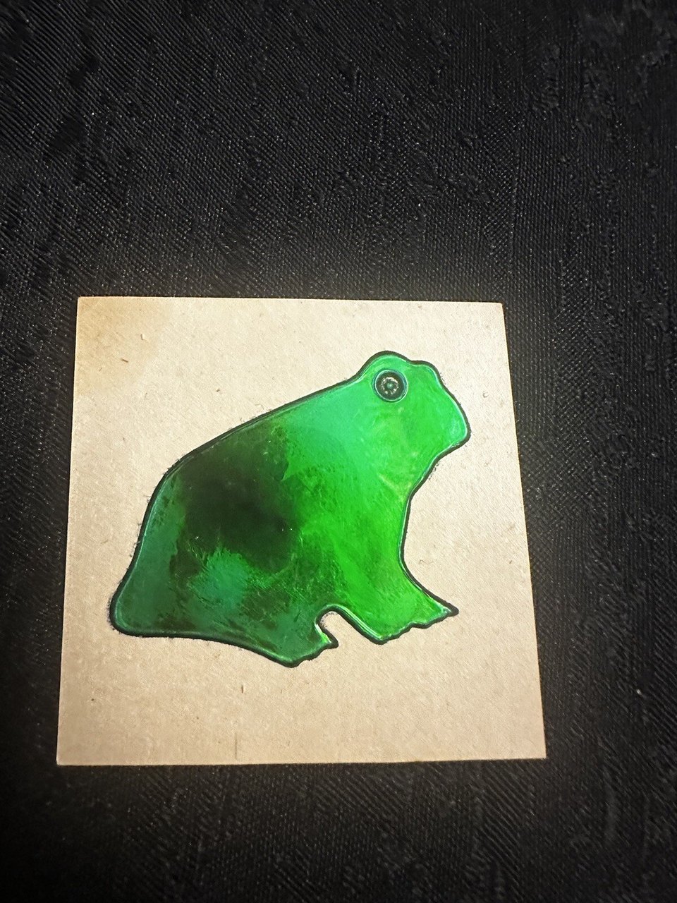 A mouthless green oily frog sticker, a little sweet and very glum