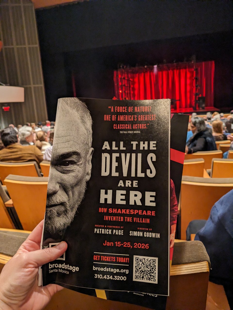A close-up of the Playbill for All the Devils Are Here: How Shakespeare Invented the Villain, foregrounding the theatre seats and the stage at the Broad Stage in Santa Monica