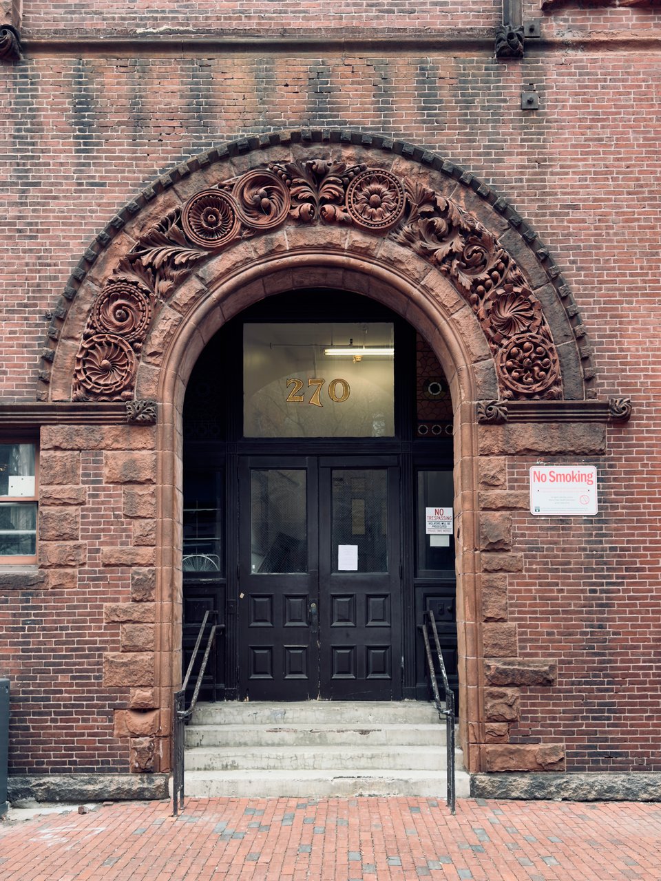 Arched brick doorway with ornate floral carvings