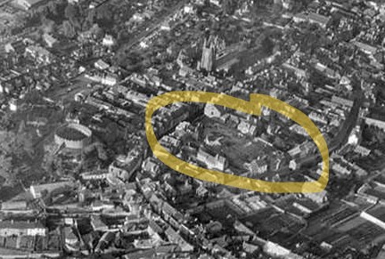Black and white aerial shot of Totnes town centre. The streets show the medieval layout beneath the castle, and a large circle has been drawn around the area razed by fire.
