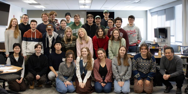 Photo shows a group of 25 Madison students posing as a group inside Case Hall.